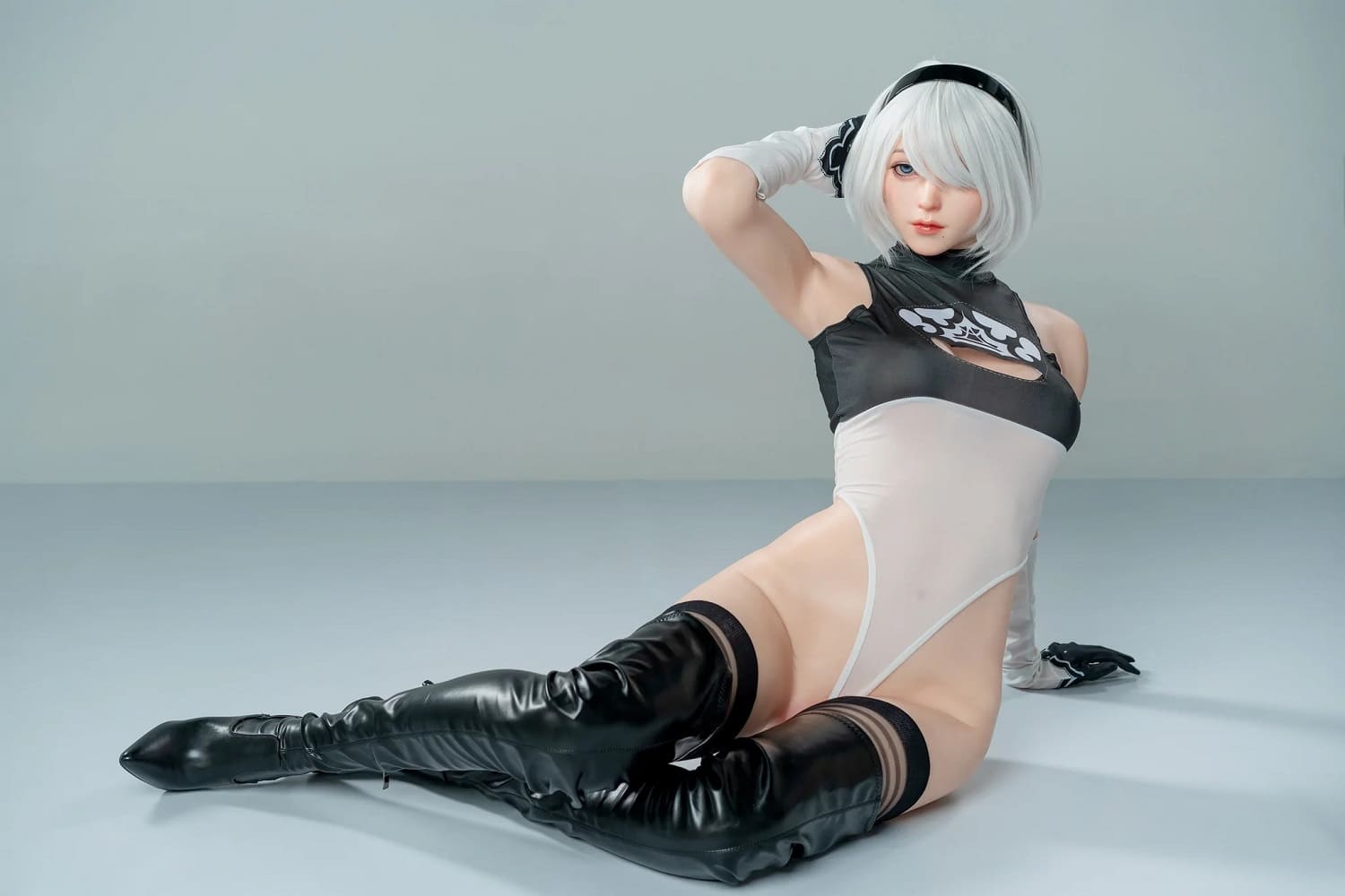 Секс-кукла Lu - фото 9 - SexDolls.com.ua Секс кукла Lu сидит на полу в черных сапогах и боди